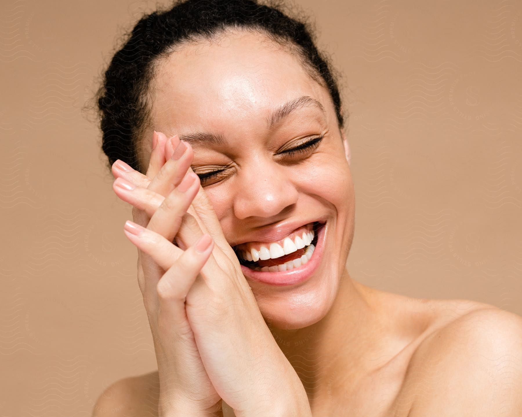 Woman laughing with her hands folded near her face