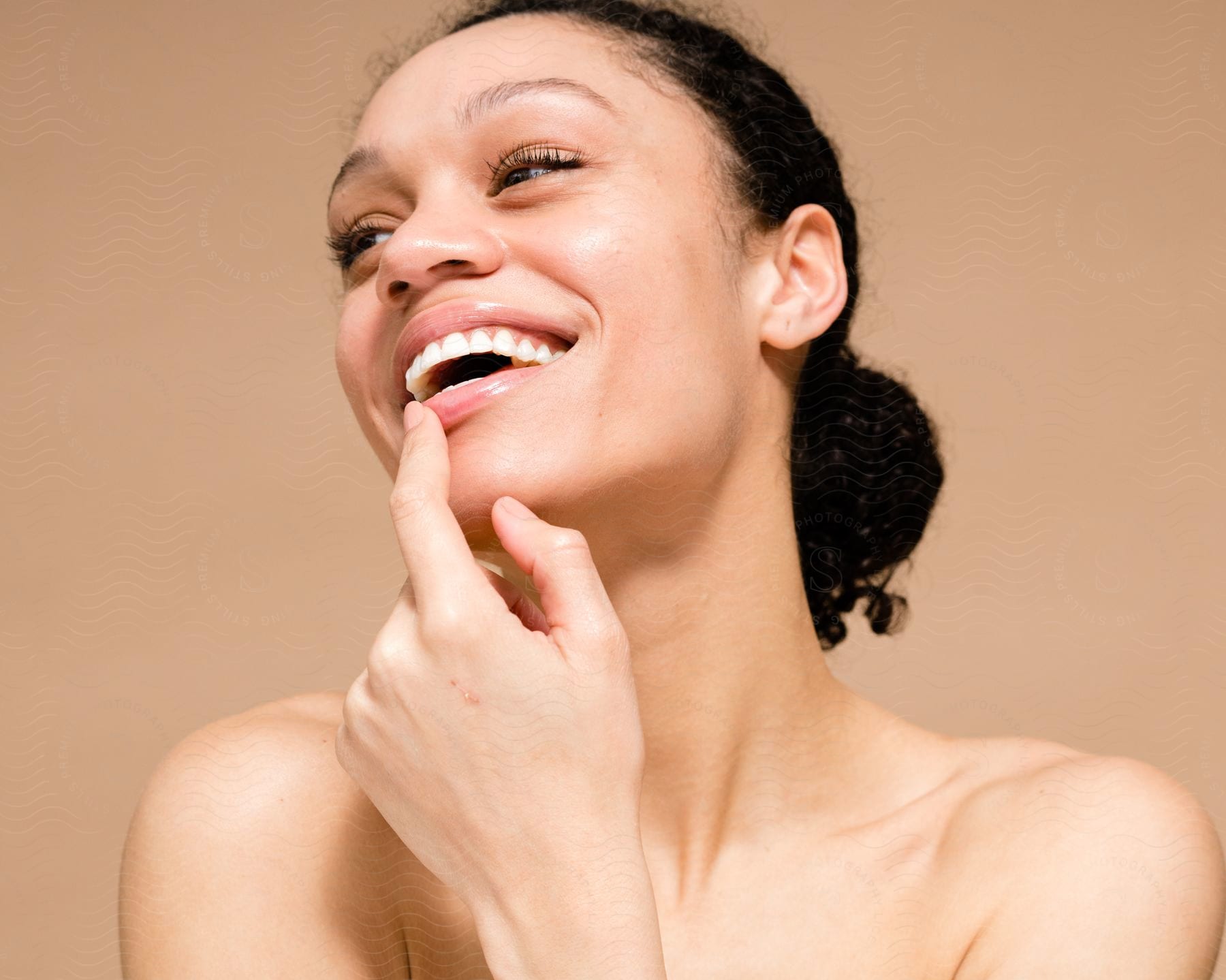 Portrait of a young smiling woman with her face glowing from skin care.