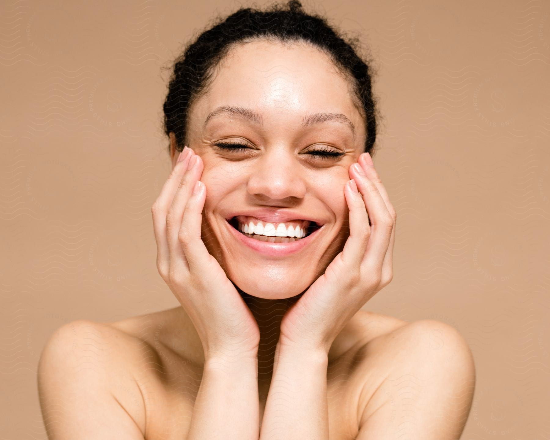 woman smiling into the camera, with her hands being held to her sides