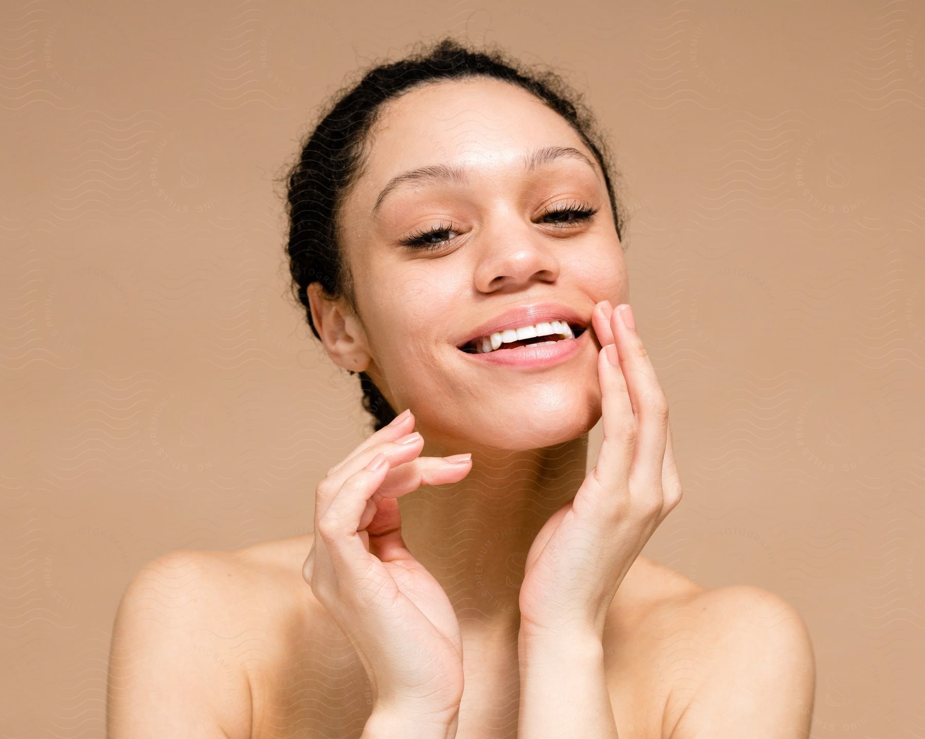 face of a lady smiling with her hands close to the chin