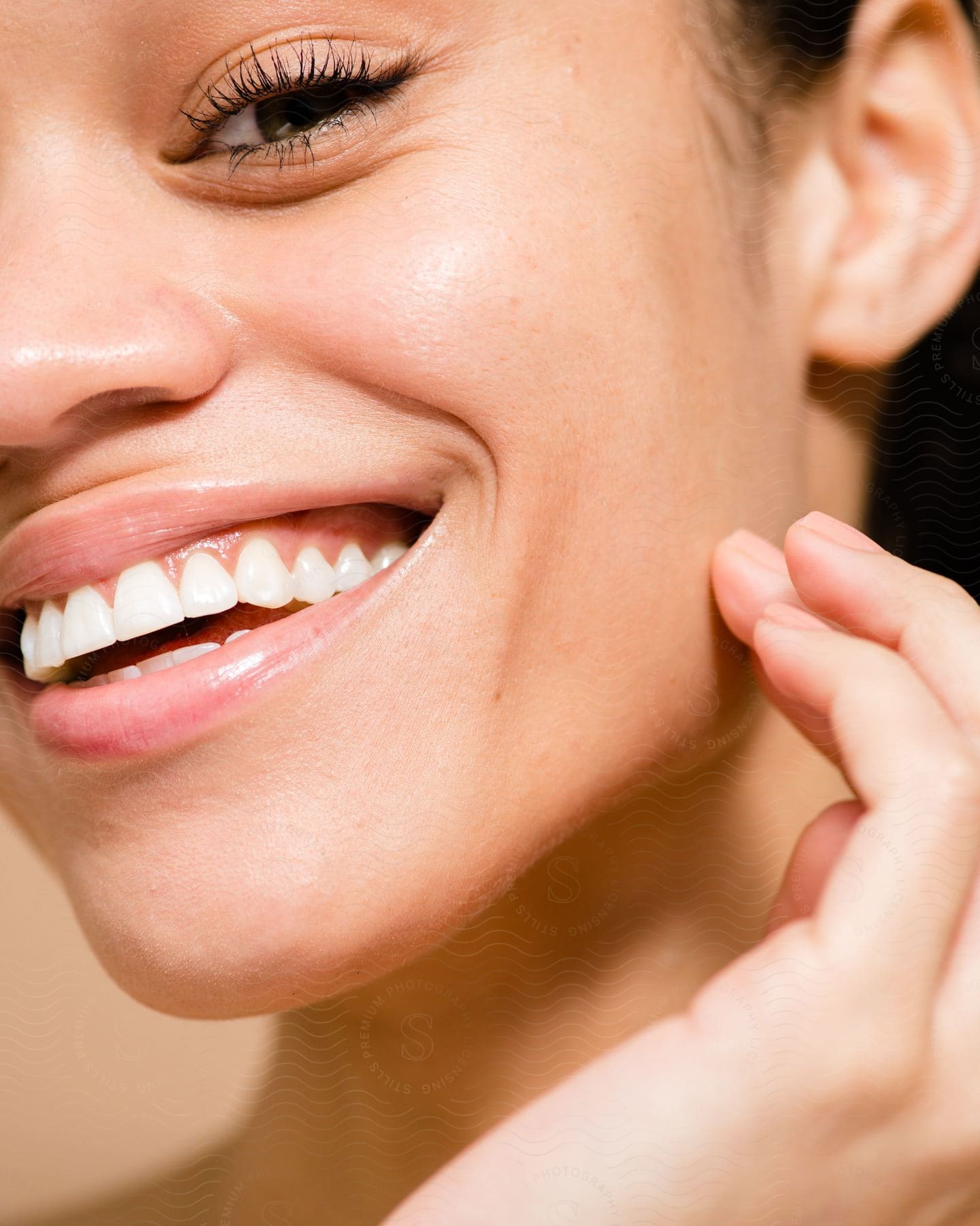 Woman touches her cheek while smiling brightly