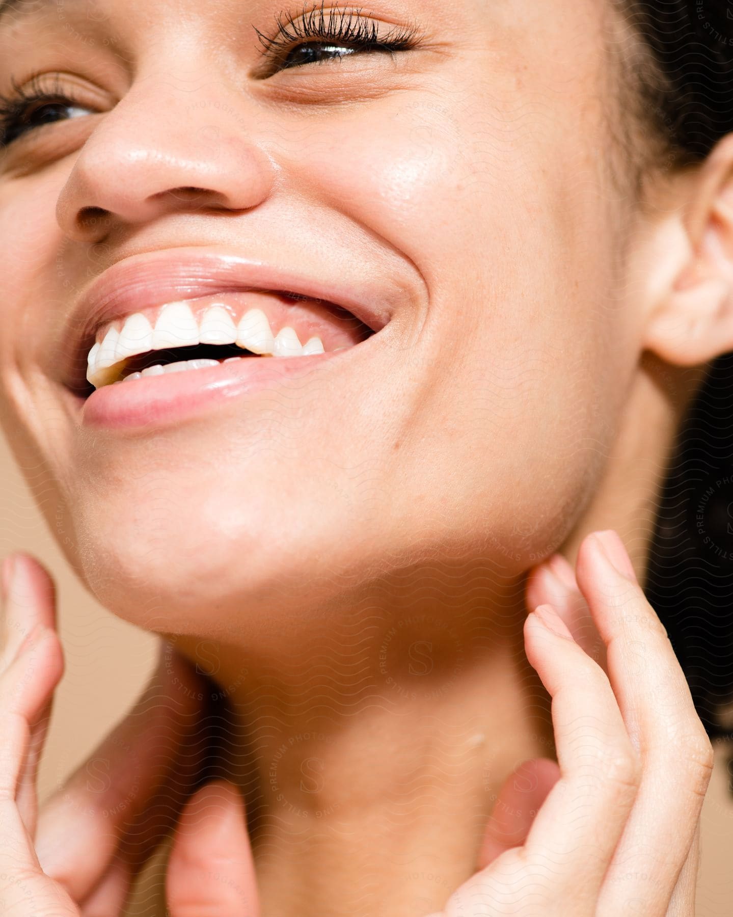 A young woman poses while pressing her fingers against her lower jaw.