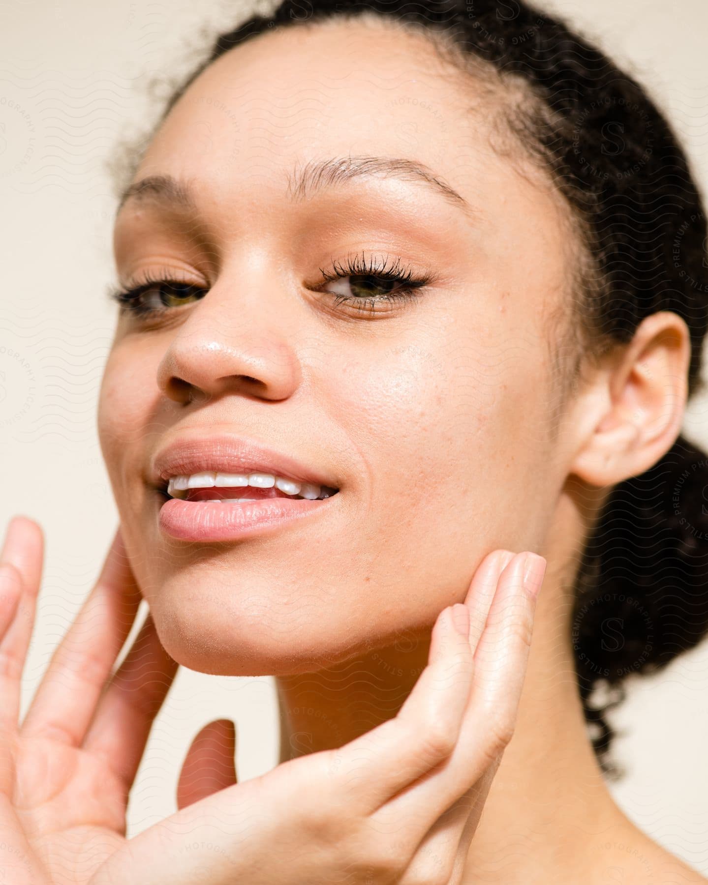 Woman is holding her fingers on the side of her face as she looks into the camera