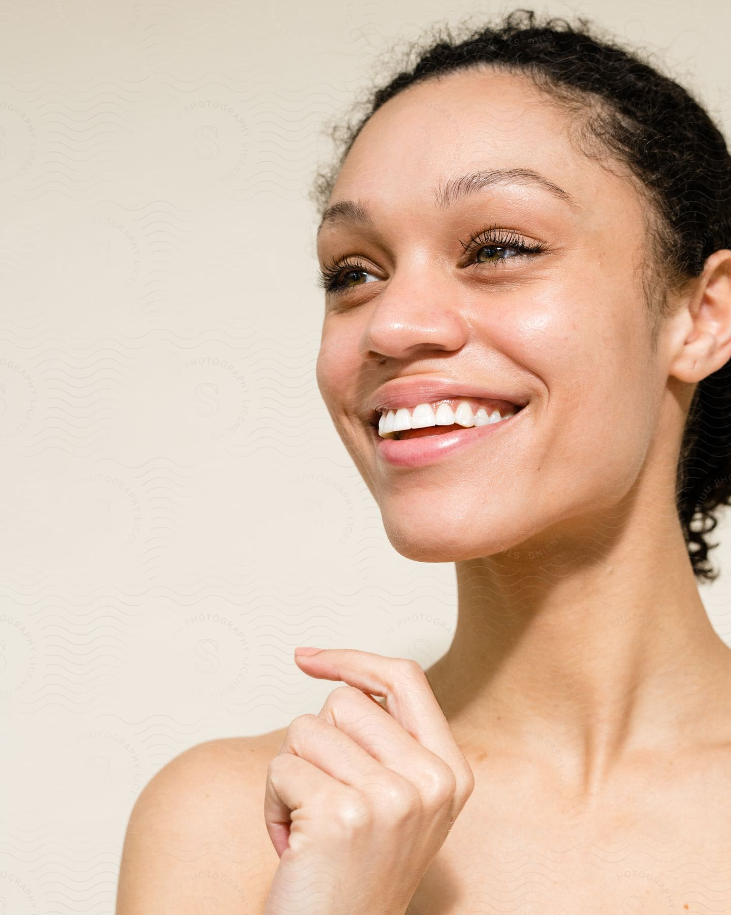 Bare-shouldered woman wearing light lipstick smiles.