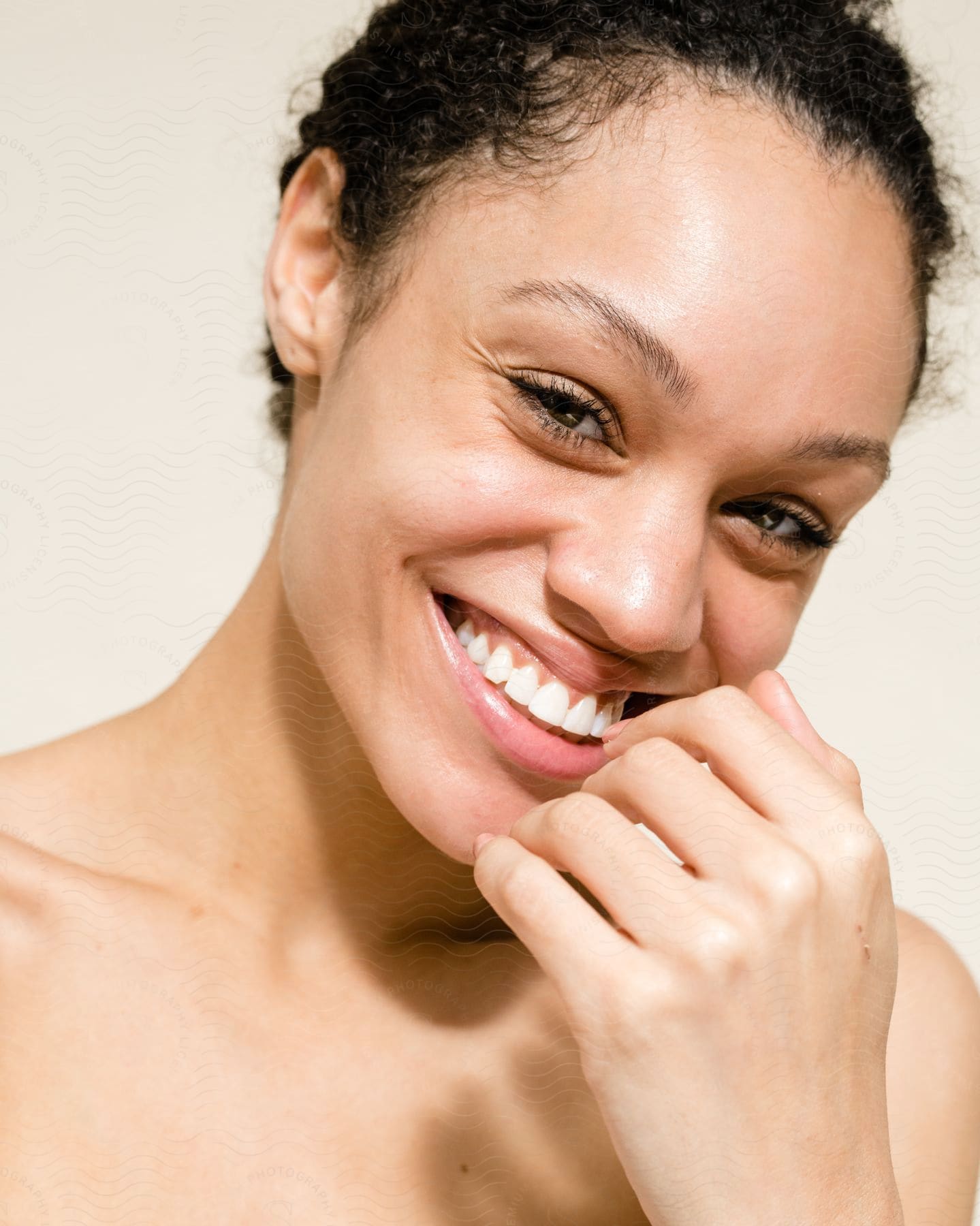 A woman smiling while touching her mouth