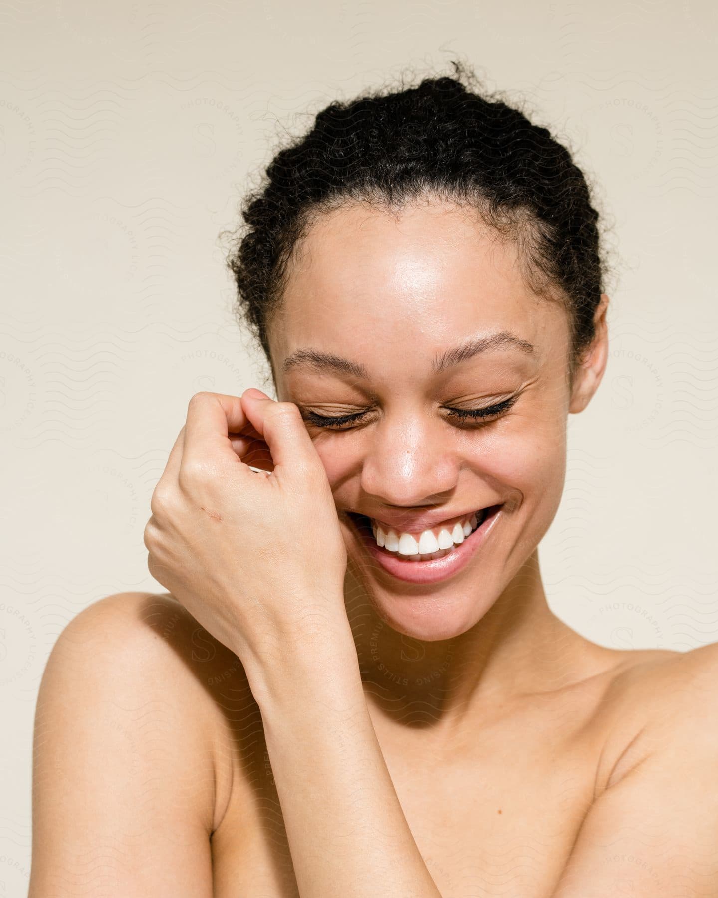 A smiling woman with her arm crossed over her shoulder.