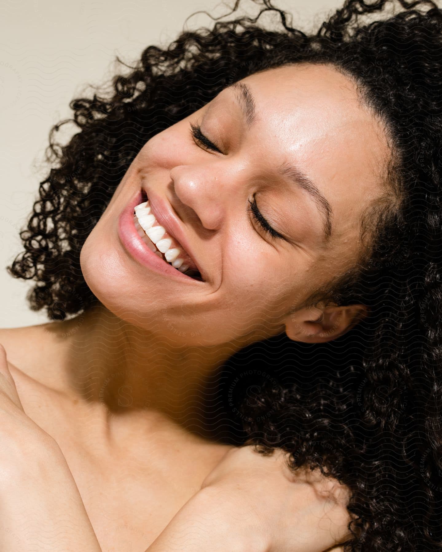 Woman is smiling with her head tilted and eyes closed