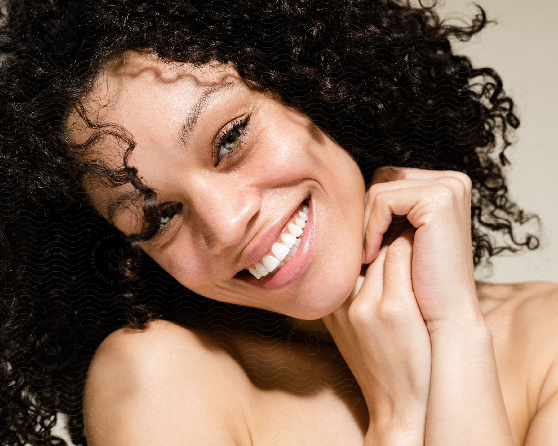 A smiling woman, with curly hair and light eyes.