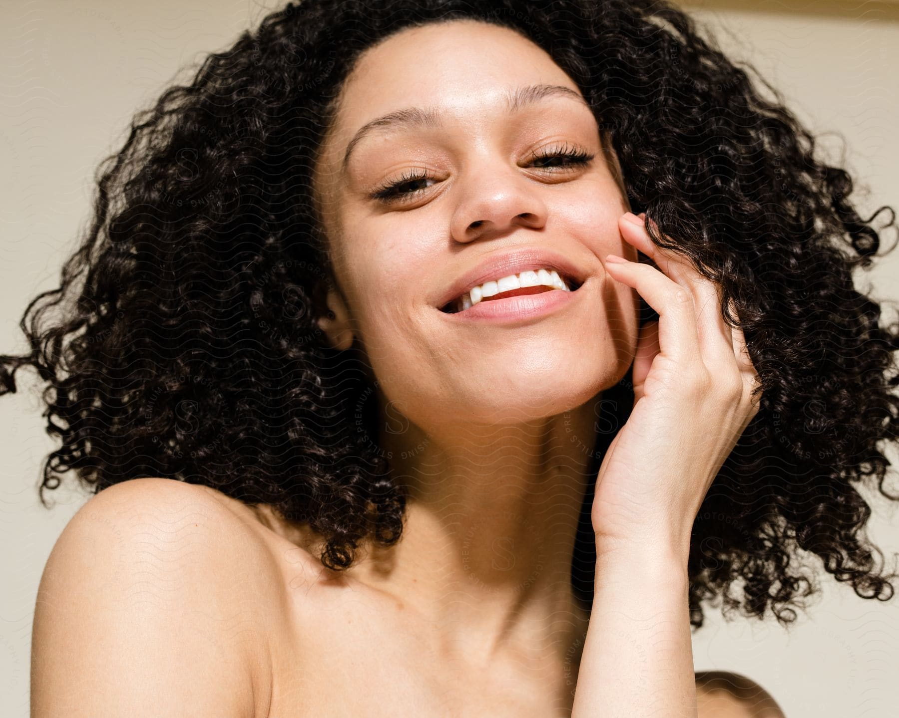 Face Of A Lady With Curly Hair, Smiling With Her Left Hand On Her Chin