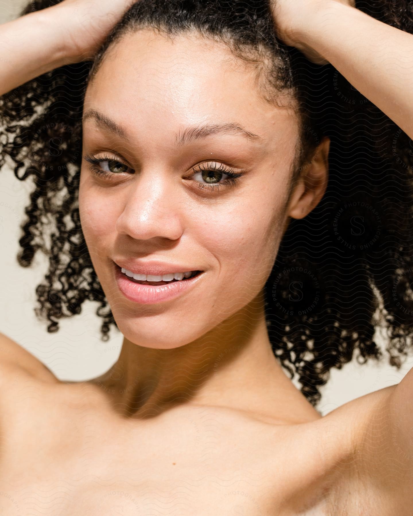 Close up of a beautiful model holding her hair up while looking at the camera