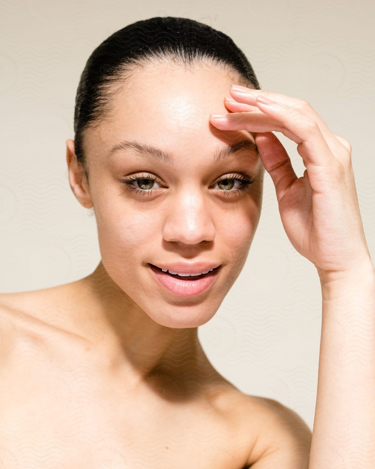 Woman touches her forehead with her fingers as she looks ahead