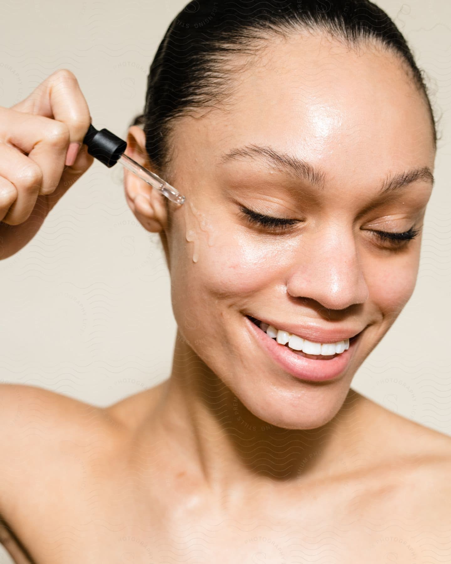 Woman smiles as she puts gel on her cheek