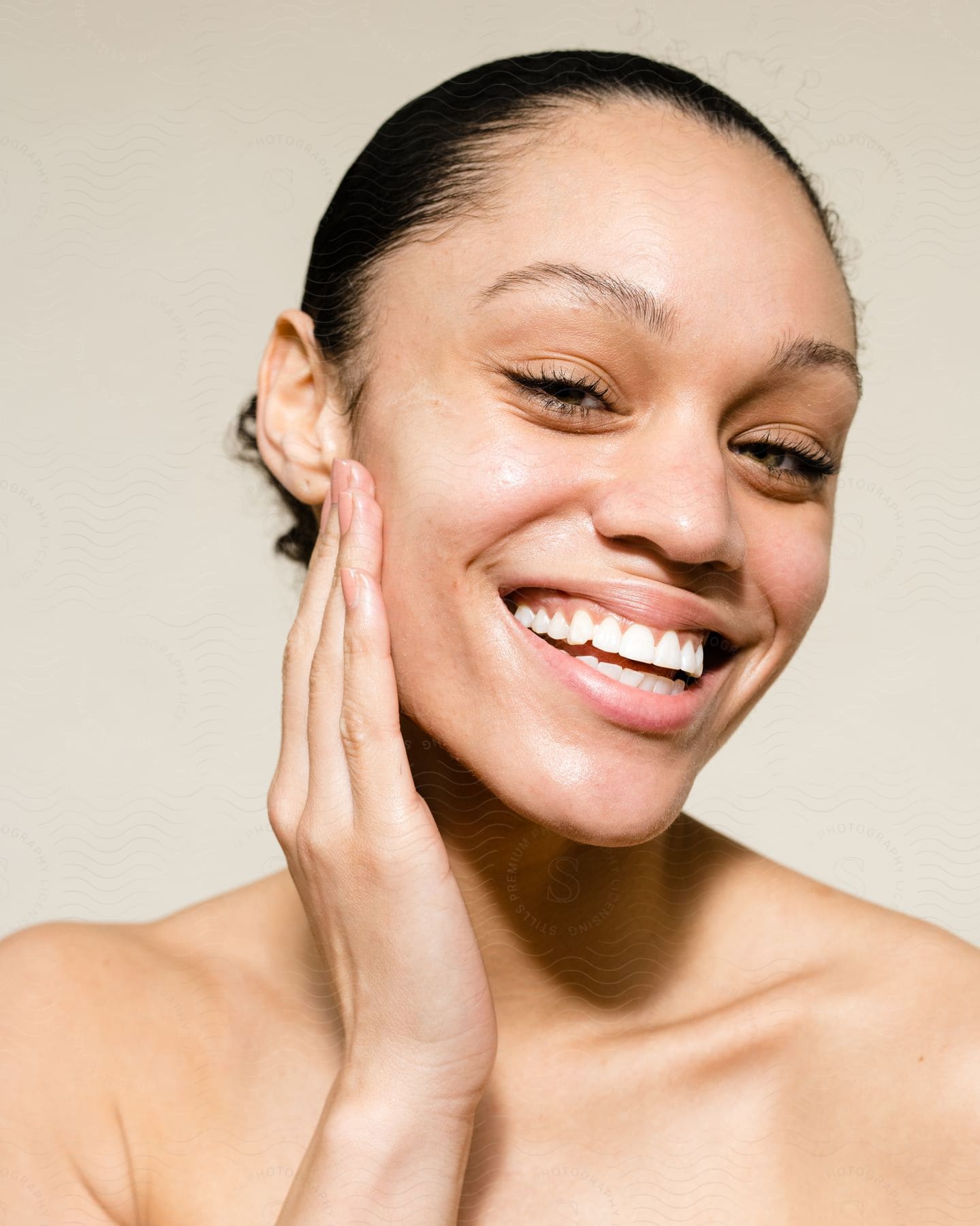 Woman smiles with her hand on the side of her face