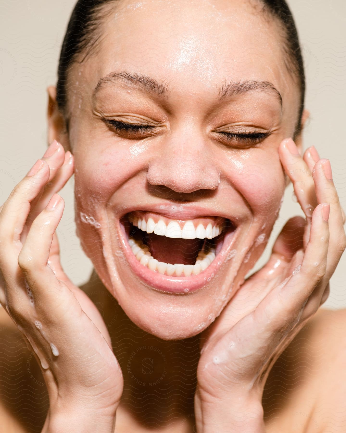 close up of a lady laughing with some liquids on her hands and mouth