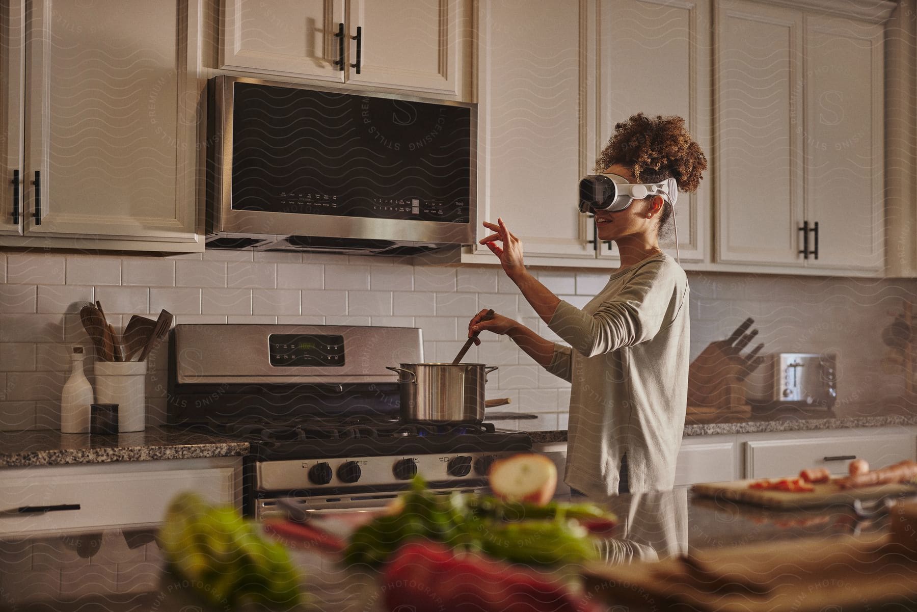 Woman in the kitchen cooking while using virtual reality glasses