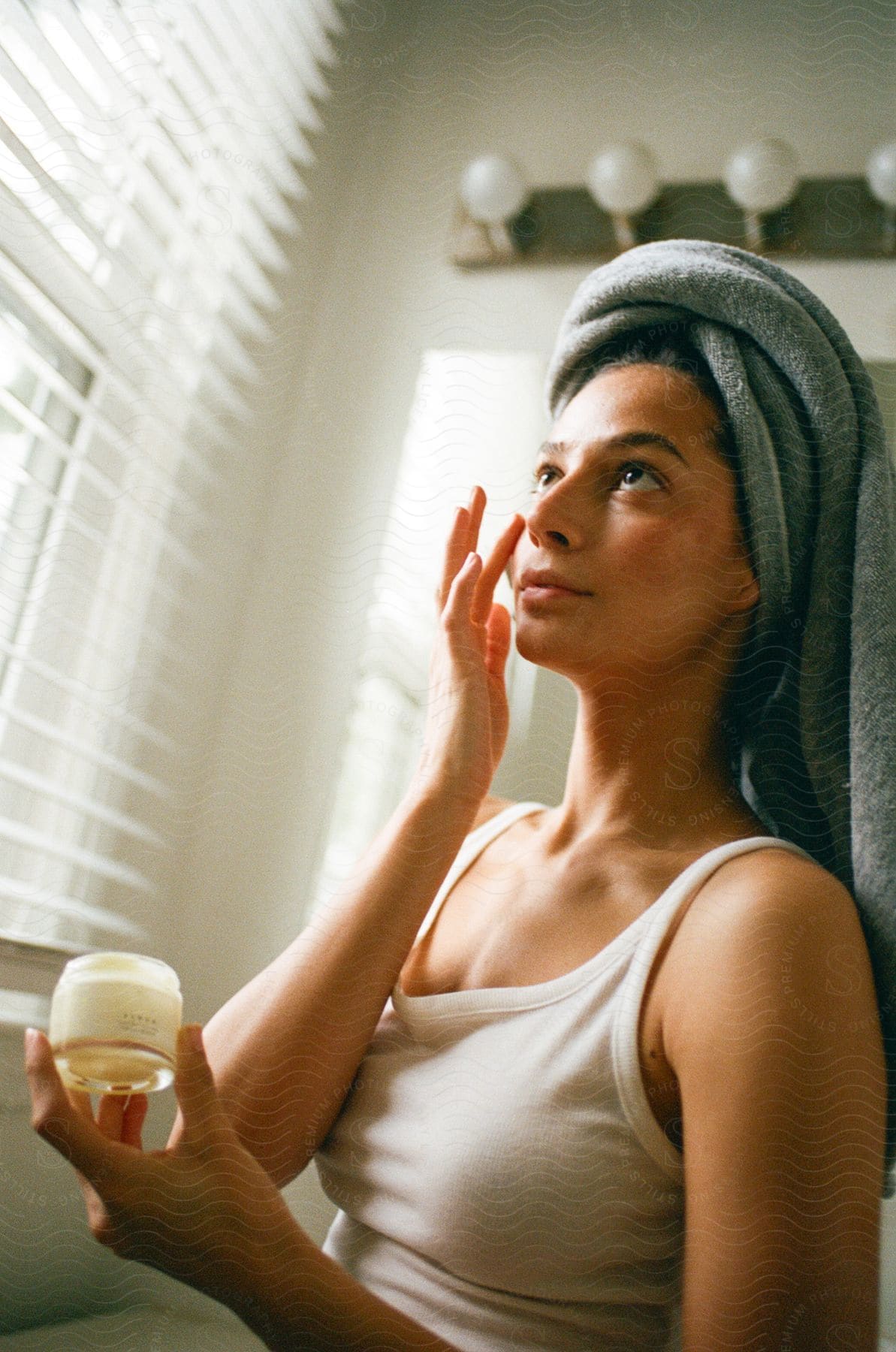 lady applying a face cream inside the bathroom