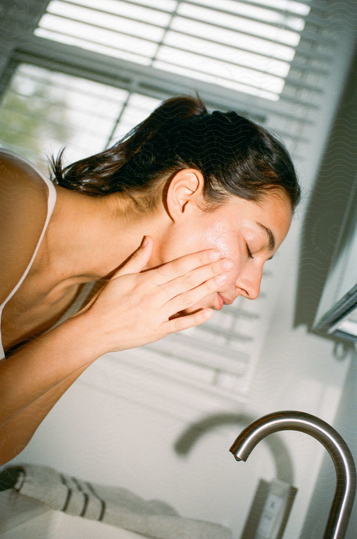 A woman washing off her face with makeup.