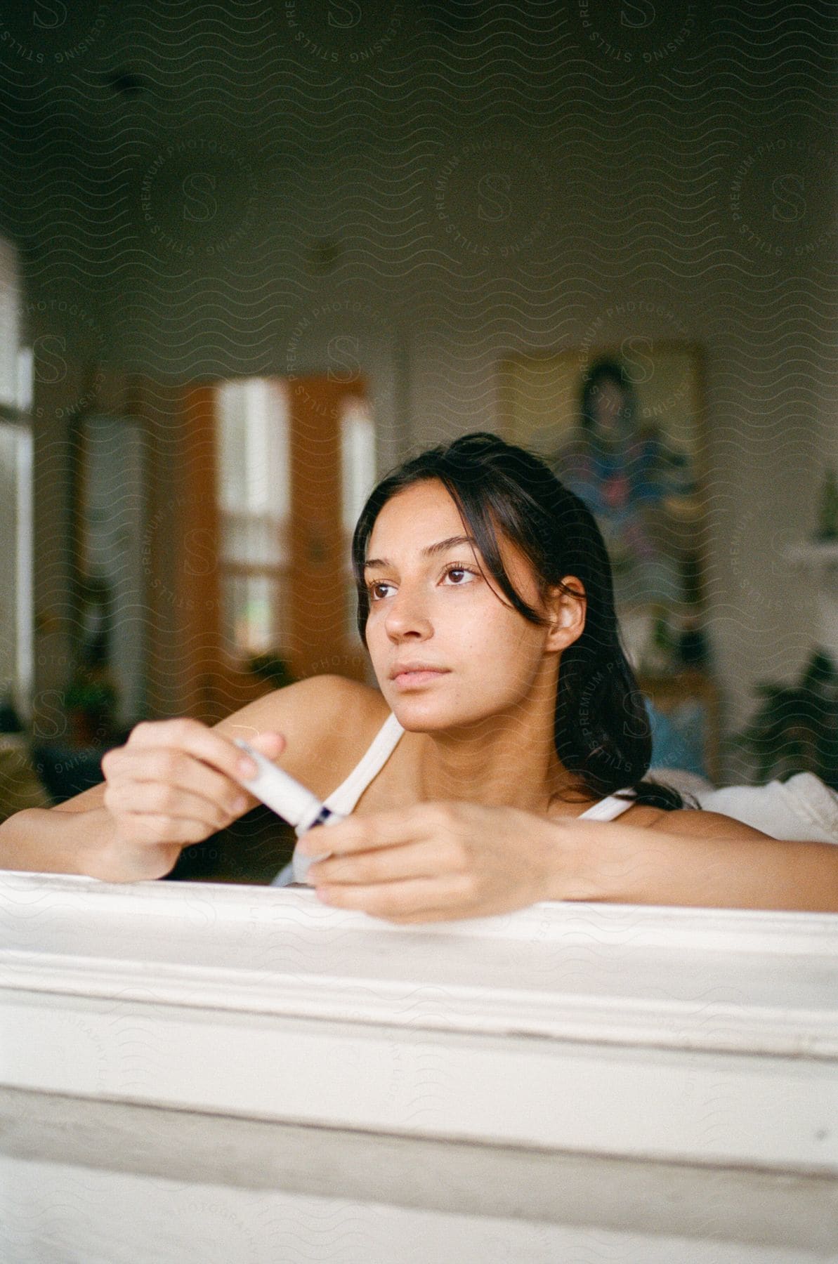 Woman wearing a white top looks out the window