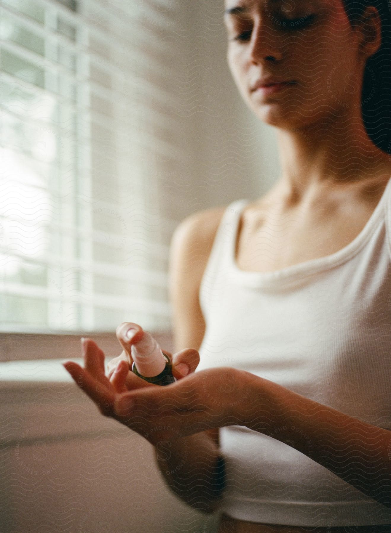 A teenage girl pumps a skincare product into the palm of her hand.