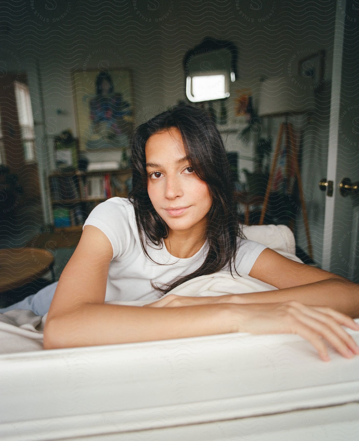 Young woman is lying with her arms in front of her as she looks ahead