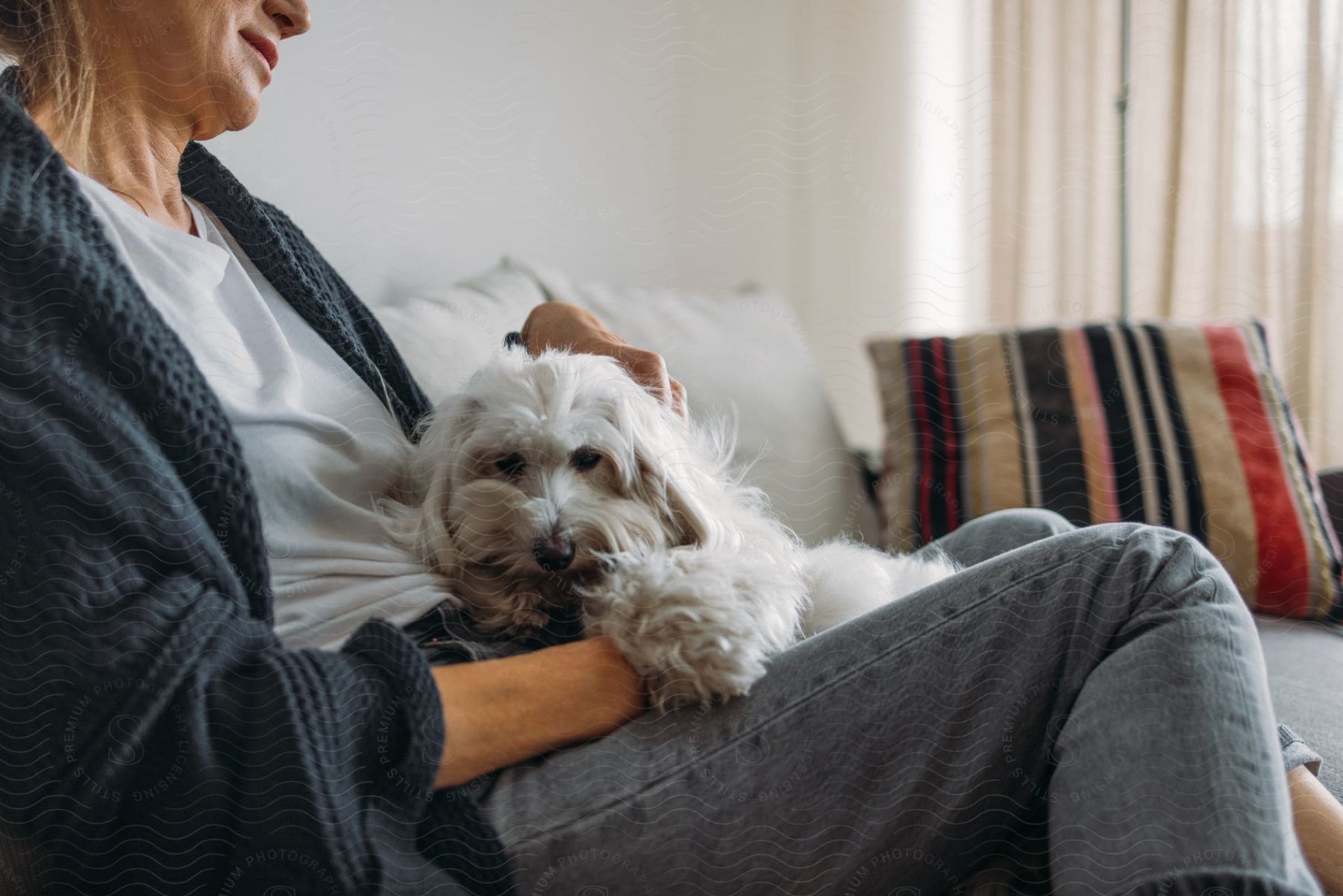 A woman is on the floor petting a dog