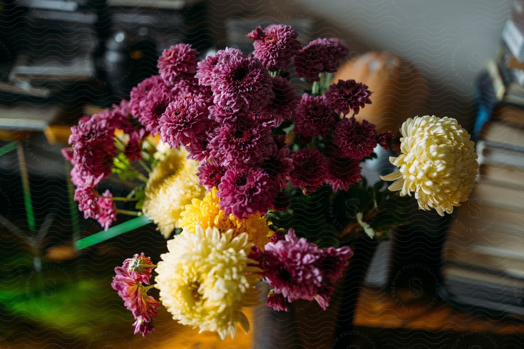 A bouquet of purple and yellow flowers are arranged in a black vase.