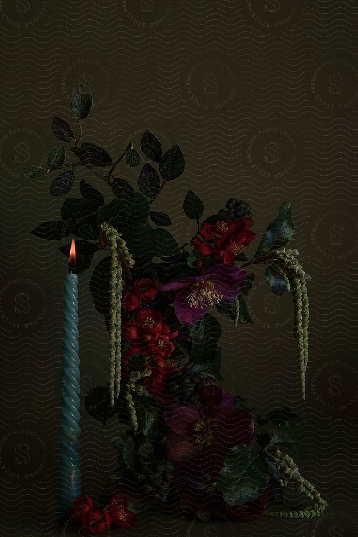 Candle burning with a flower arrangement