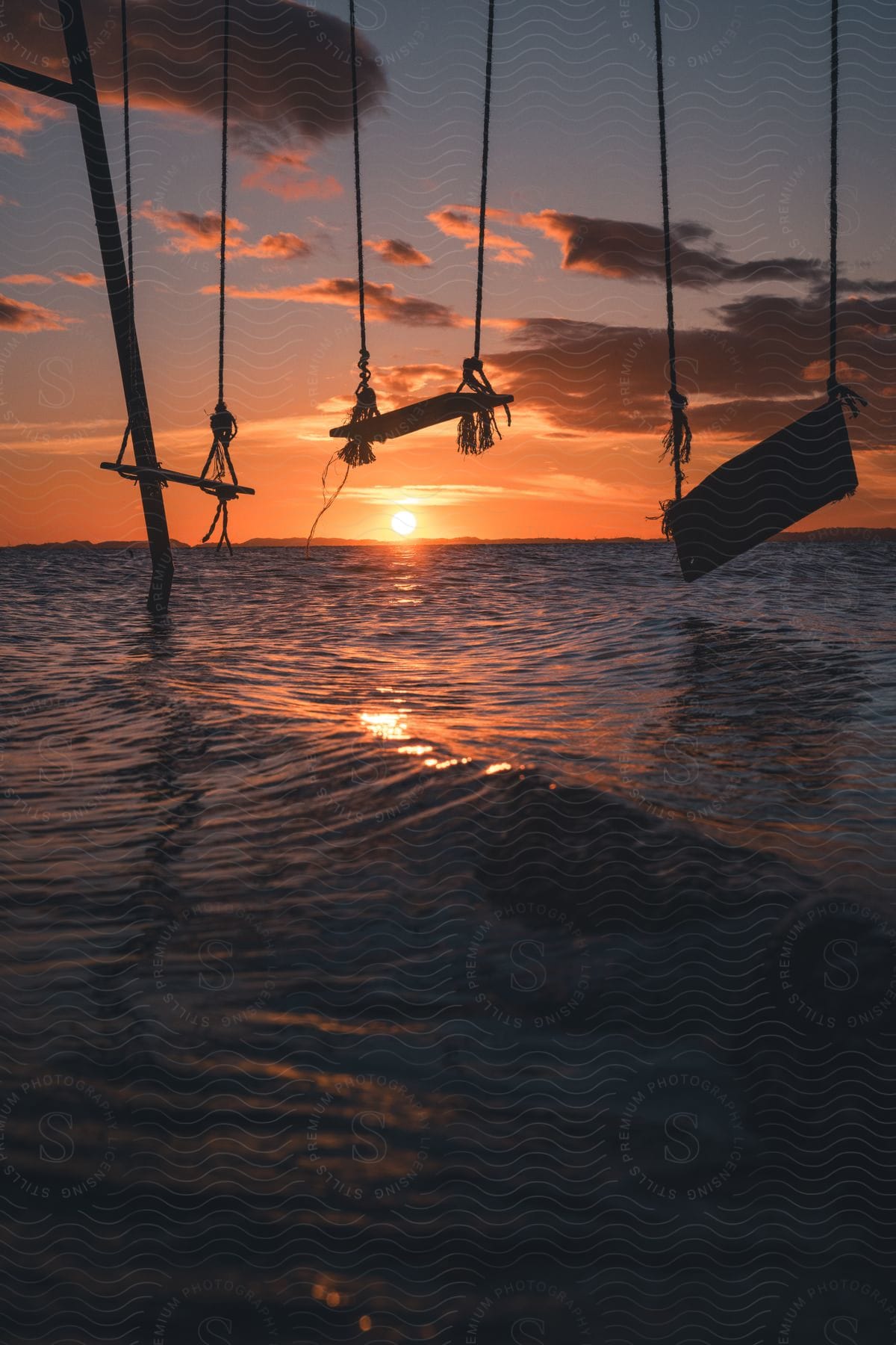 at sundown on the beach series of swings sit in the water