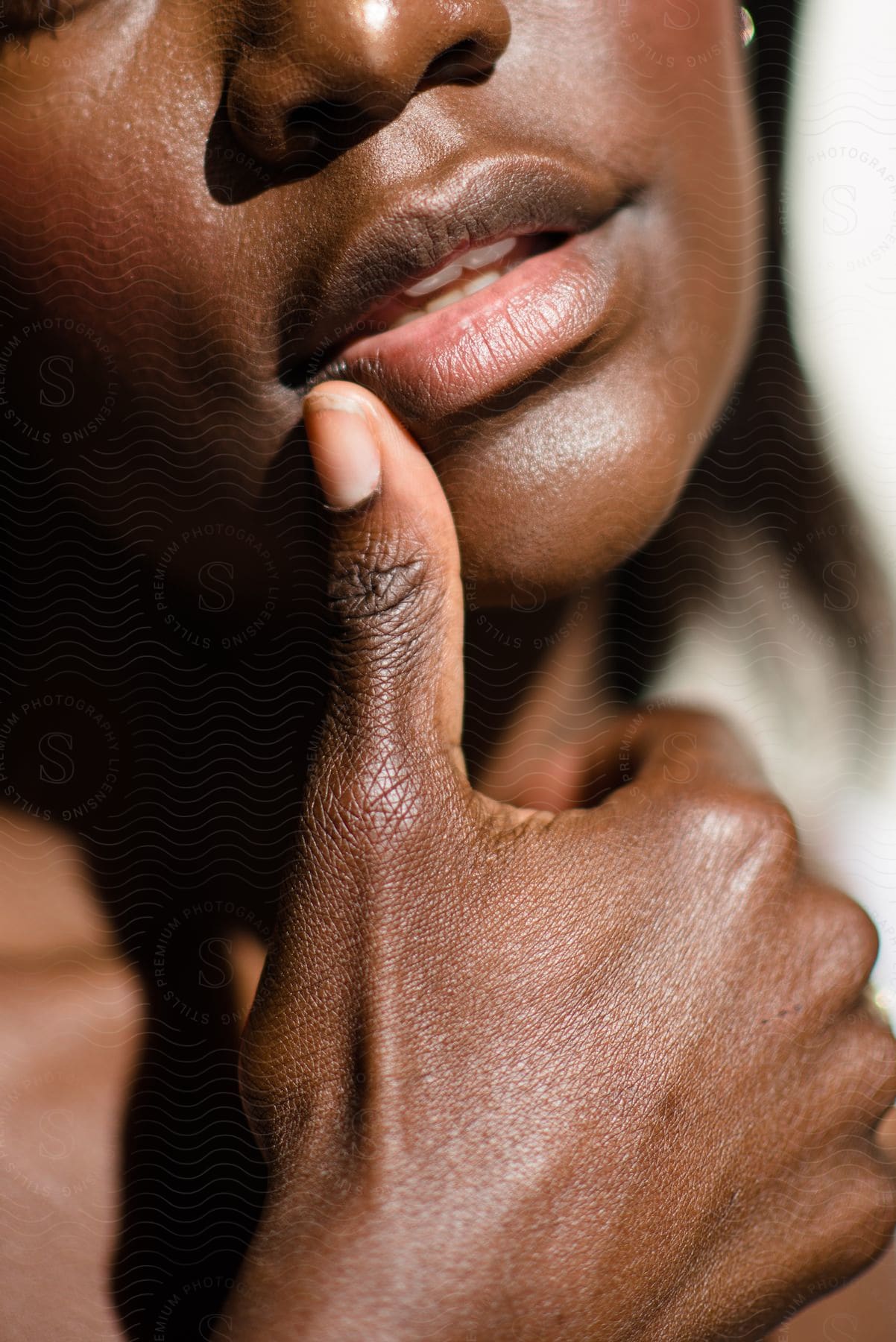 a black young lady placed her thumb on her lip