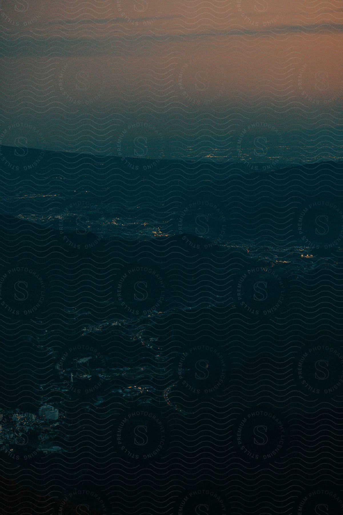 Aerial of a city surrounded by mountains at night.