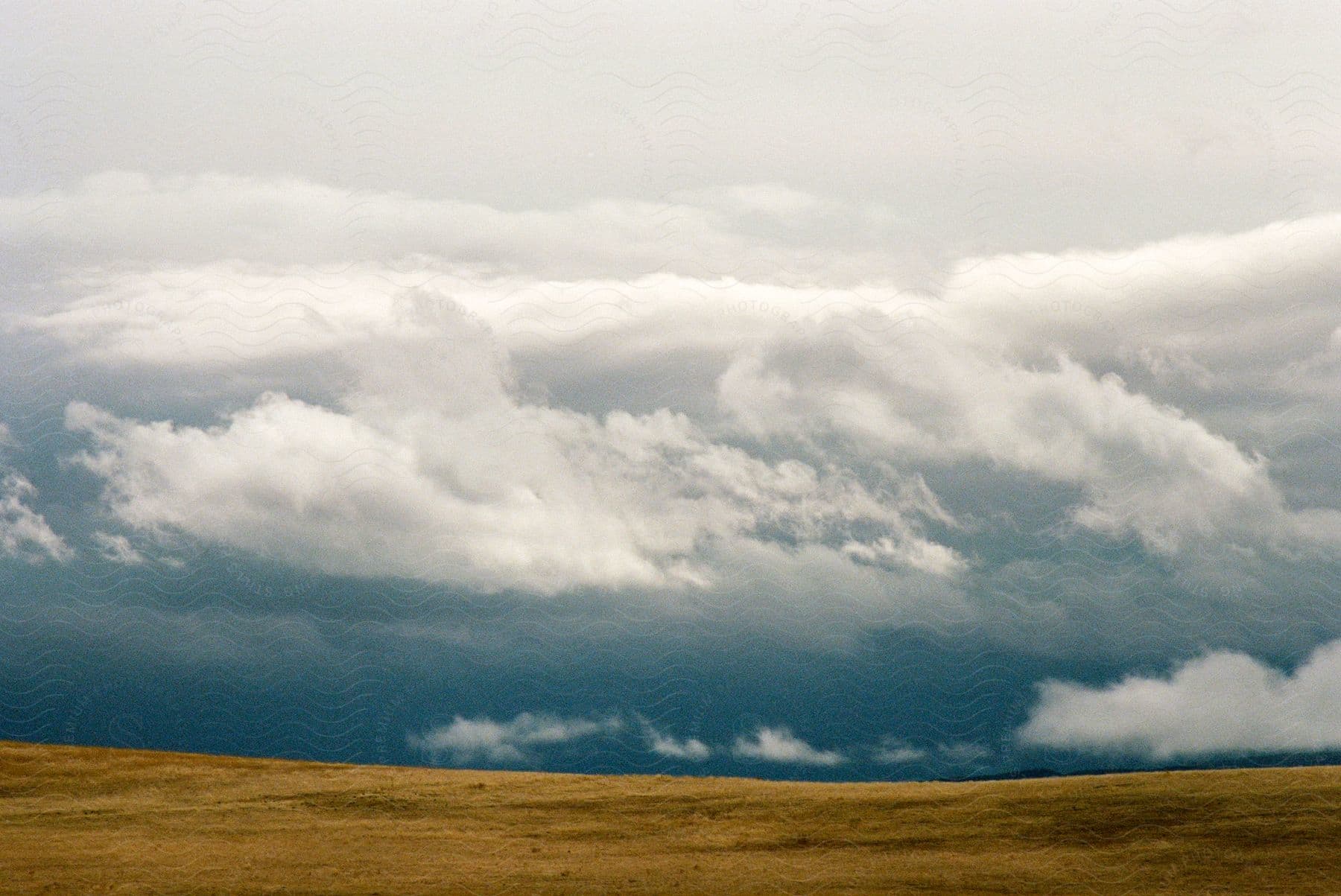 Clouds gathering over a grass plain