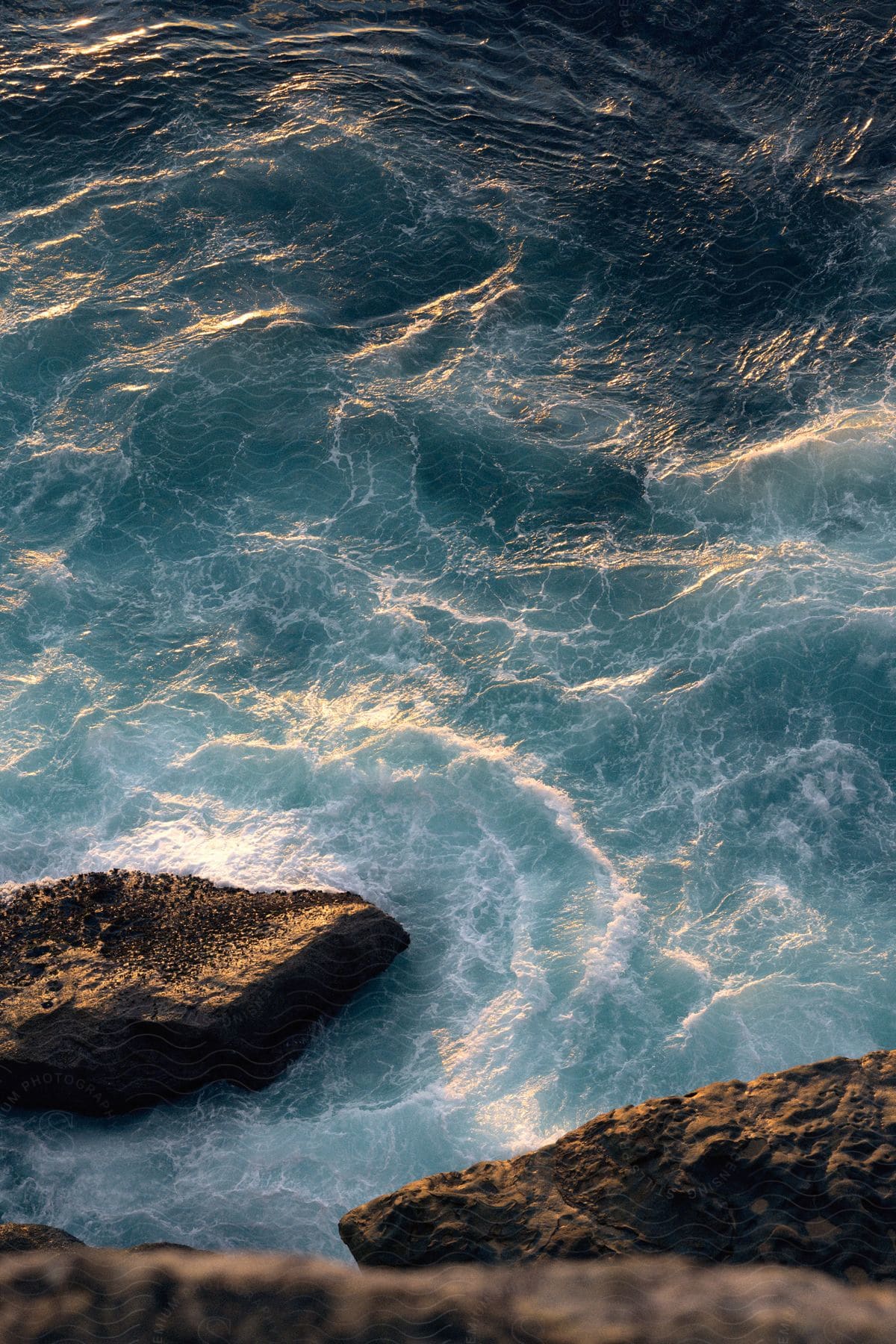 wind cause the ocean to be unsettled as a rock sits being undisturbed by the ocean wave