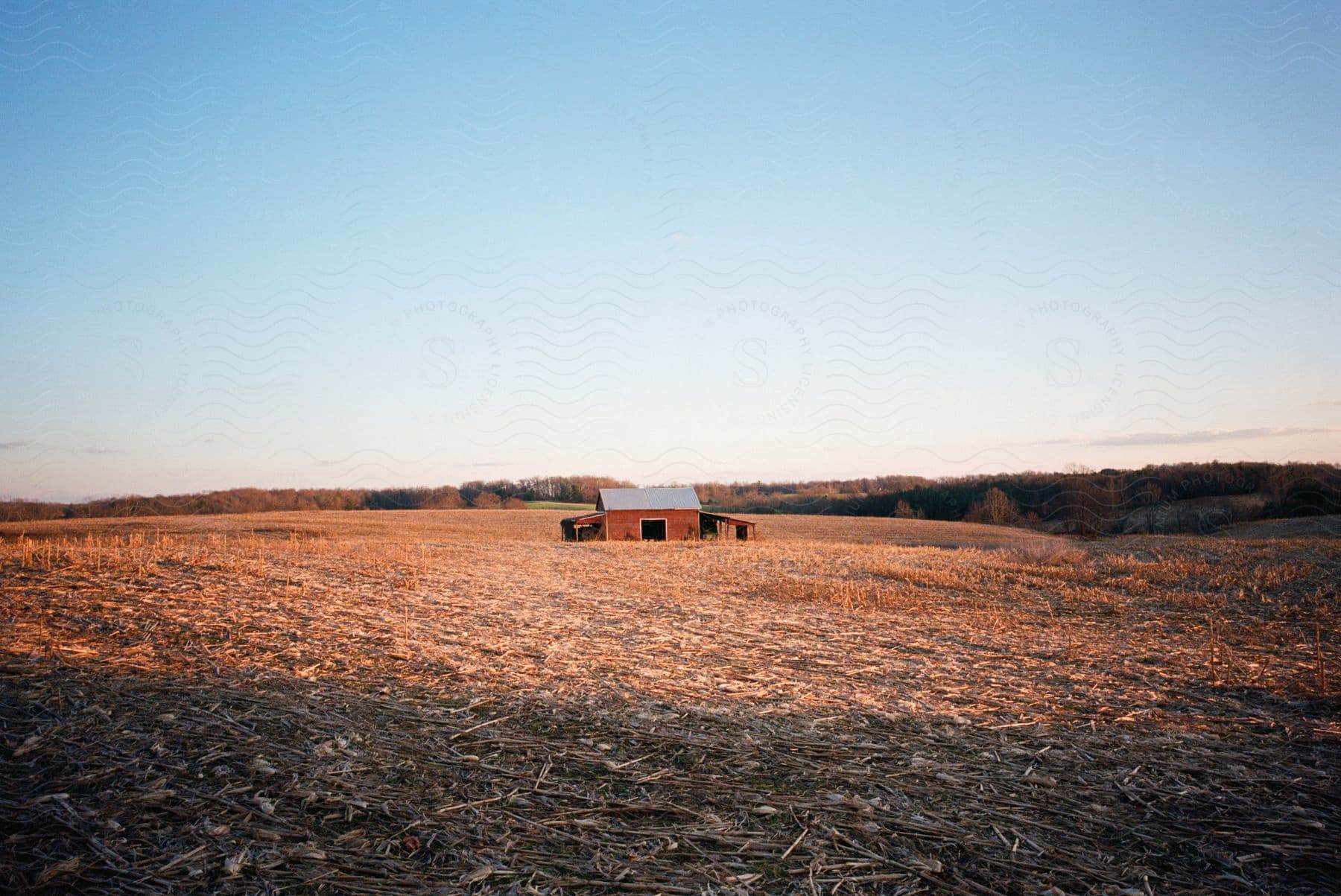 Stock photo of farmhouse in a plowed open farm field