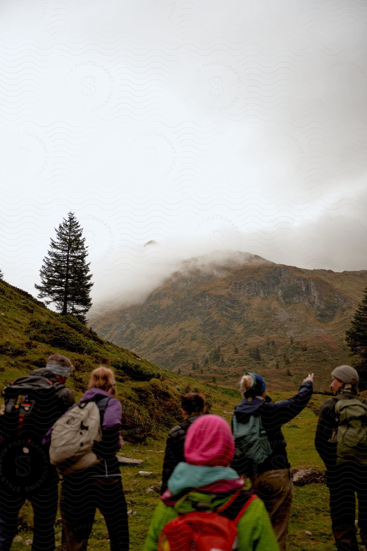 A group of hikers near a foggy mountain