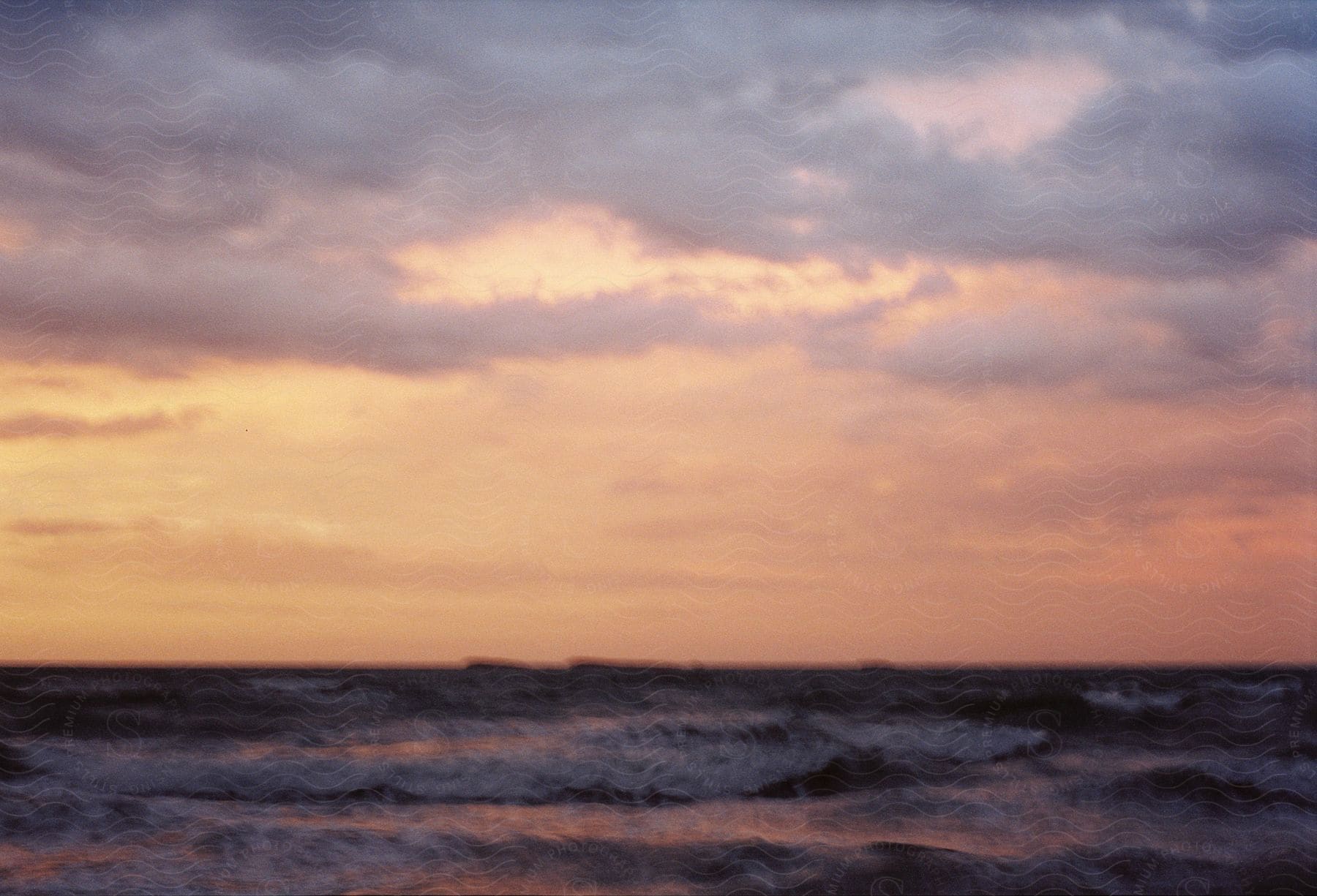 At sunrise in the ocean, the sky turns red, casting a crimson hue over the waves.