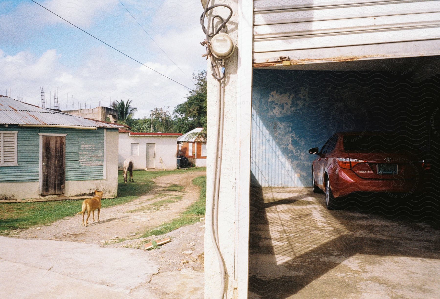 Simple houses in a residential neighborhood with a parked red car.