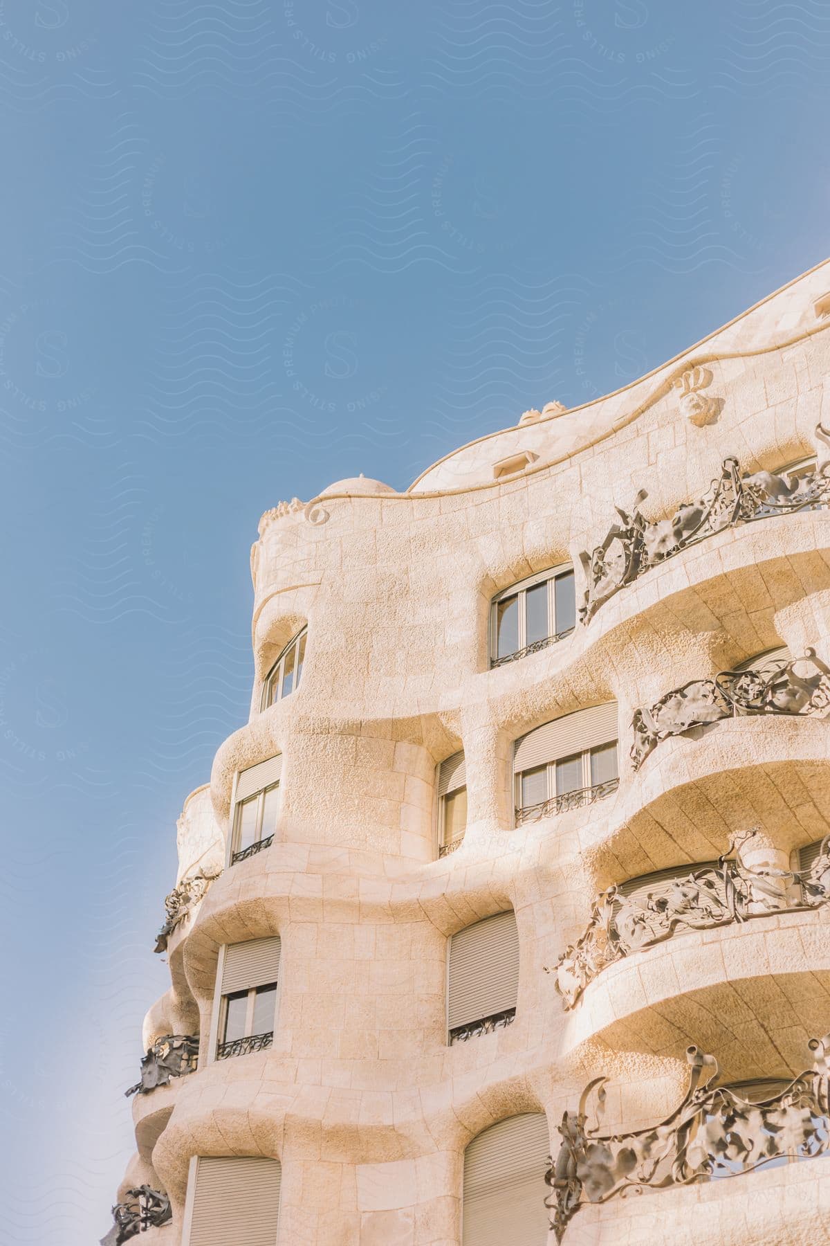 A unique, curved architectural building with smooth surfaces and no straight lines or sharp angles, under a clear blue sky.