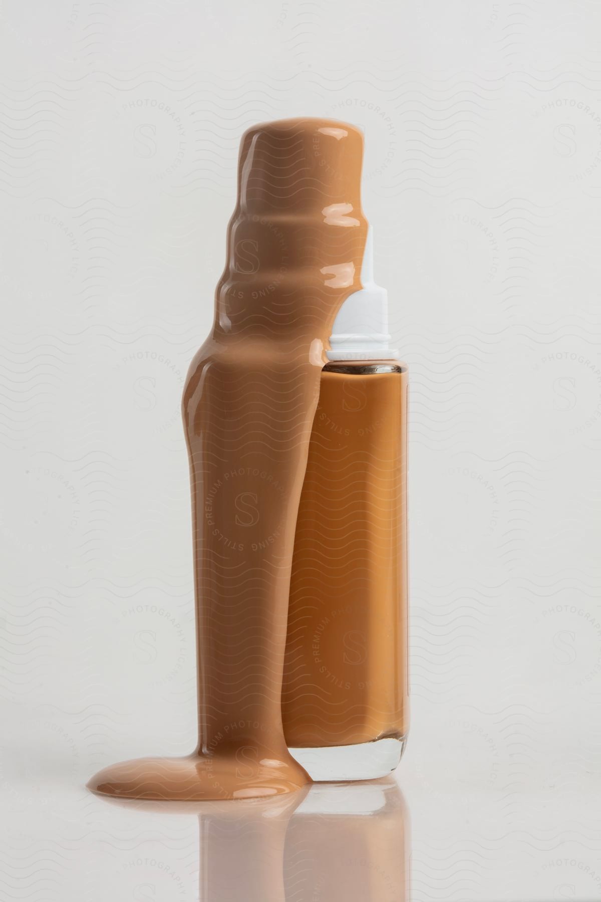 A bottle of foundation is overflowing, with make-up liquid dripping down the sides.