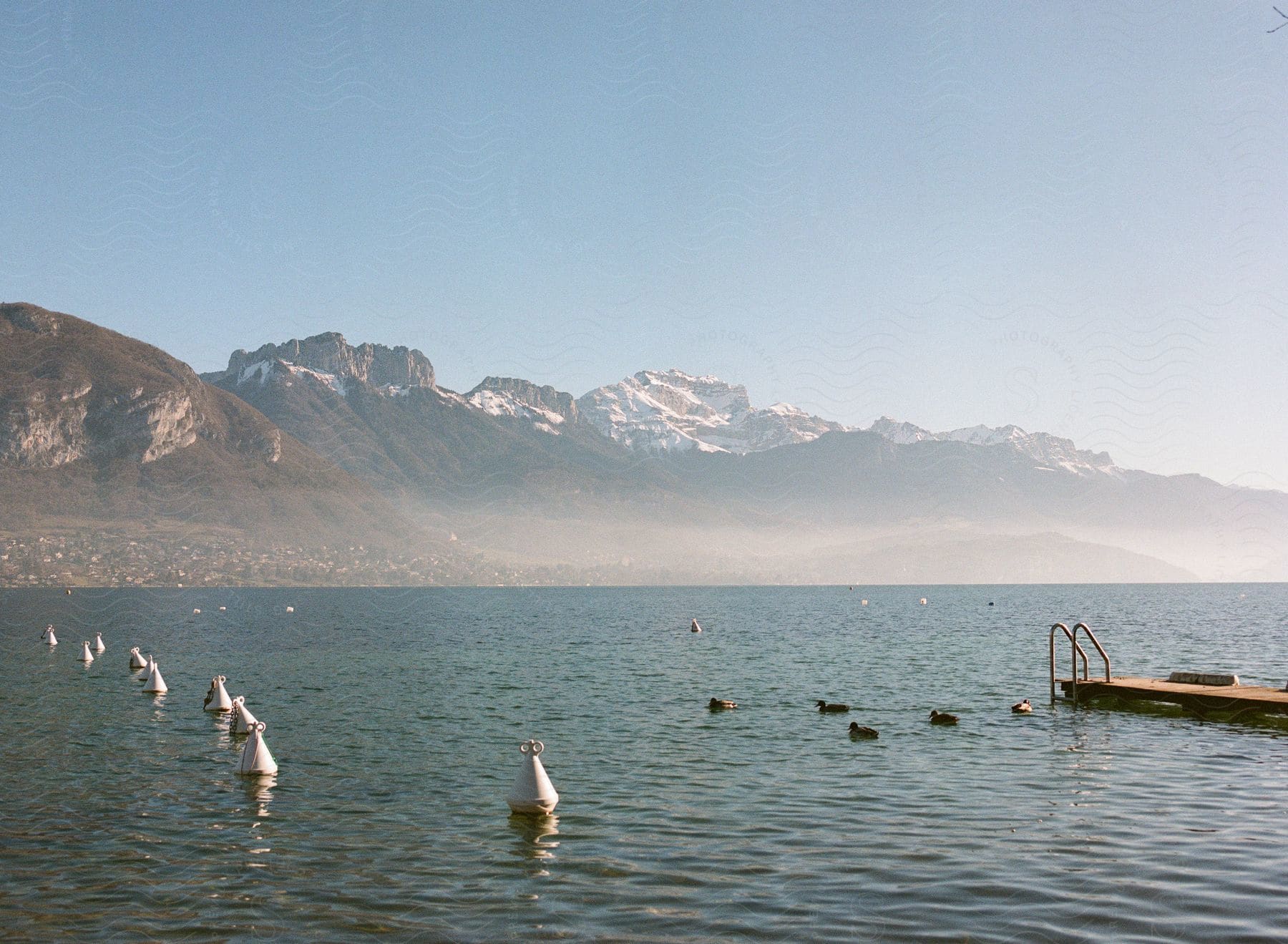 Sea scenery with buoys and a view of mountains with snow on the horizon