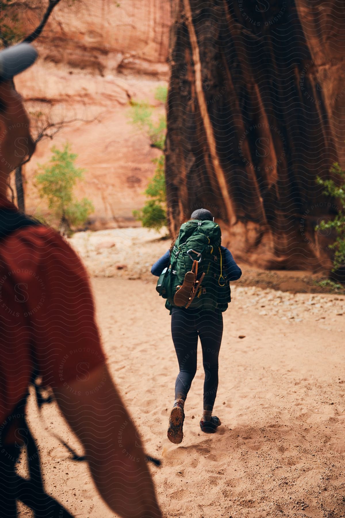 Two people walking through the sand and in the middle of natural canyons.