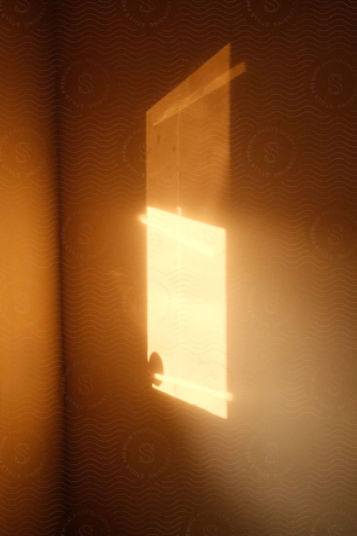 Natural light hitting a wall making a rectangular and very bright shape and the wall is orange