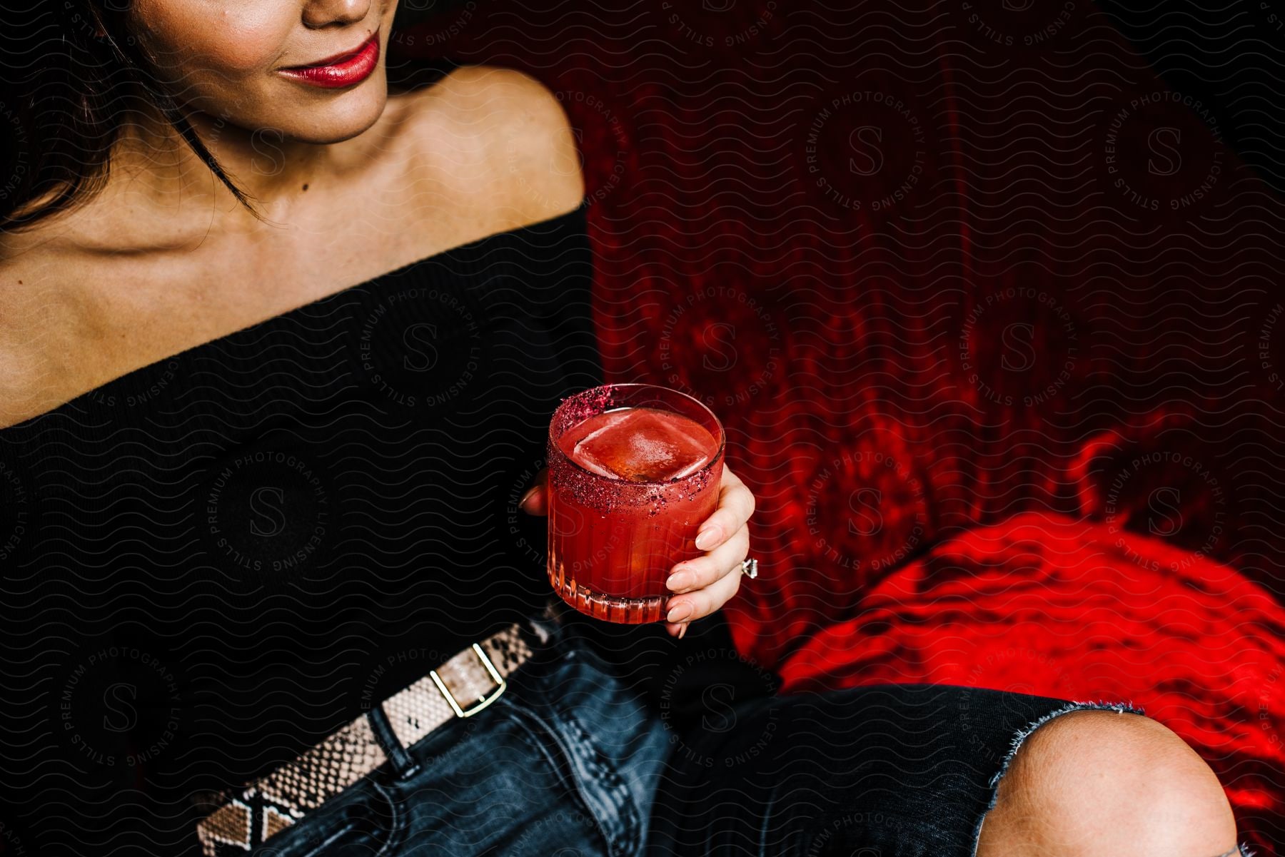 Woman's hand holding a drink with red ice