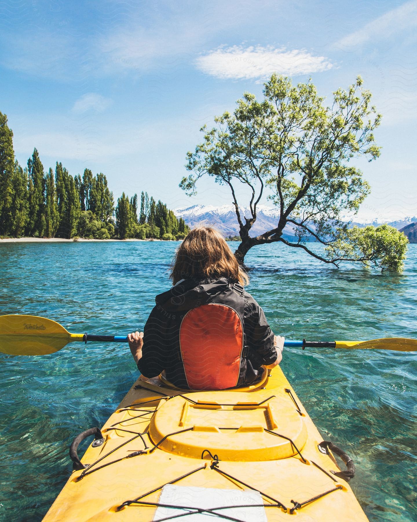 A woman kayaking outdoors on a sunny day