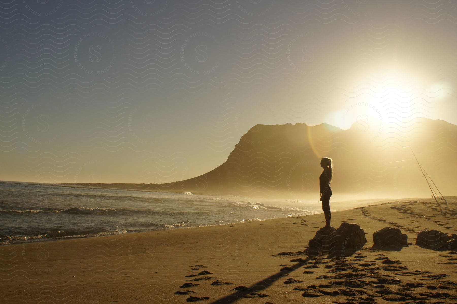 A woman standing outdoors on the beach on a sunny day