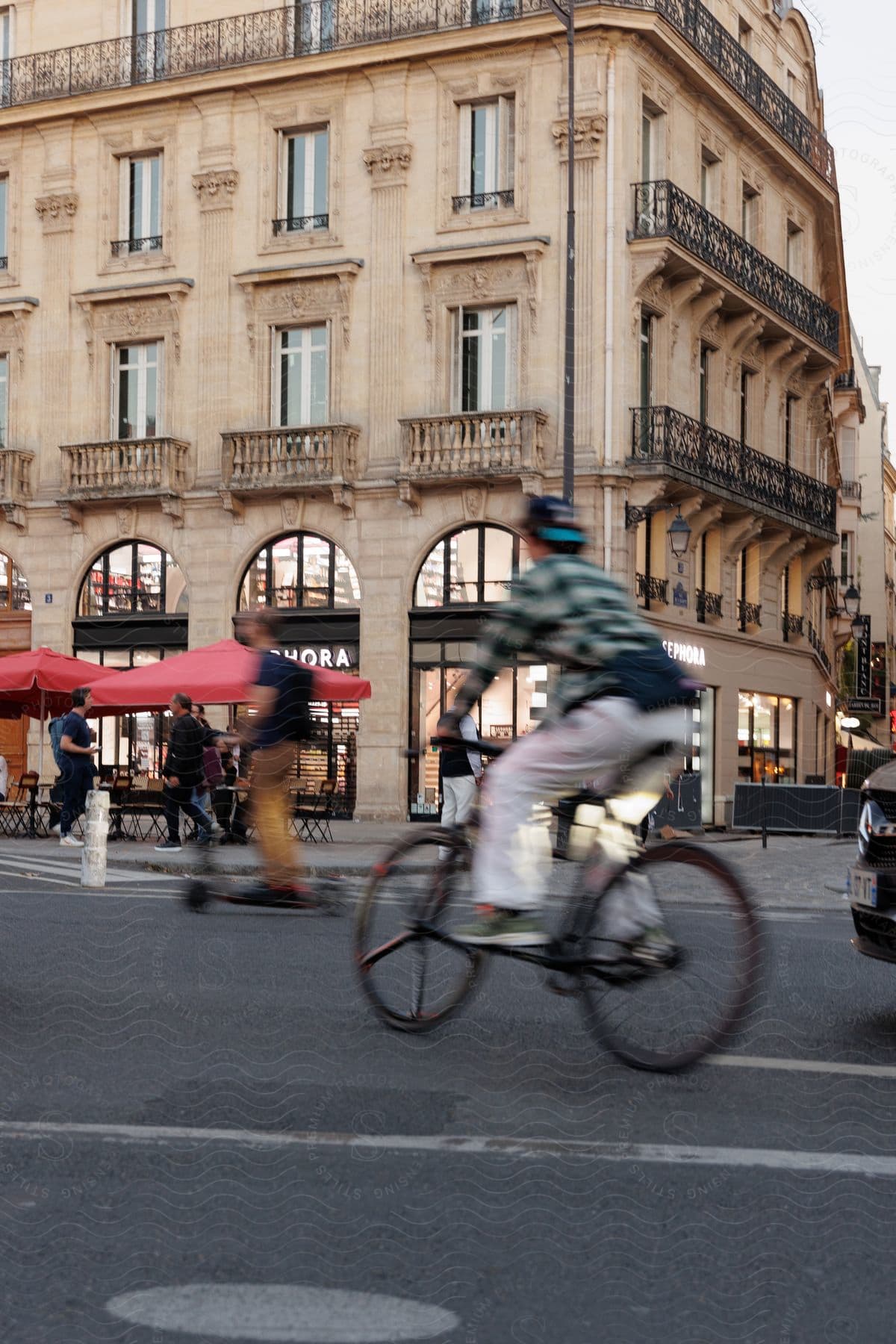 Street Of An Urban City With People On Bicycles And Pedestrians Walking