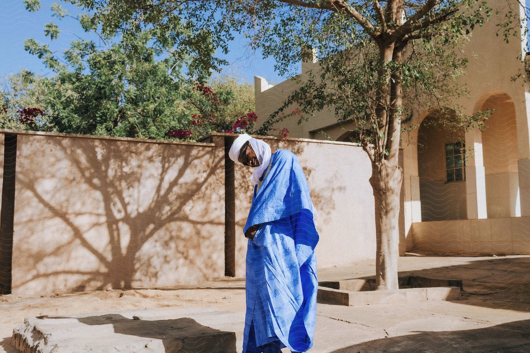 A young African person laughing standing in front of a wall.