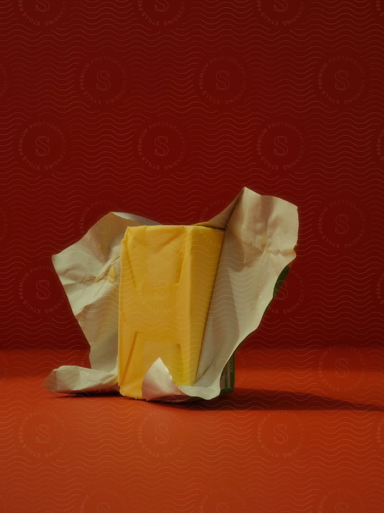 A block of cheese sitting on a table in a room.