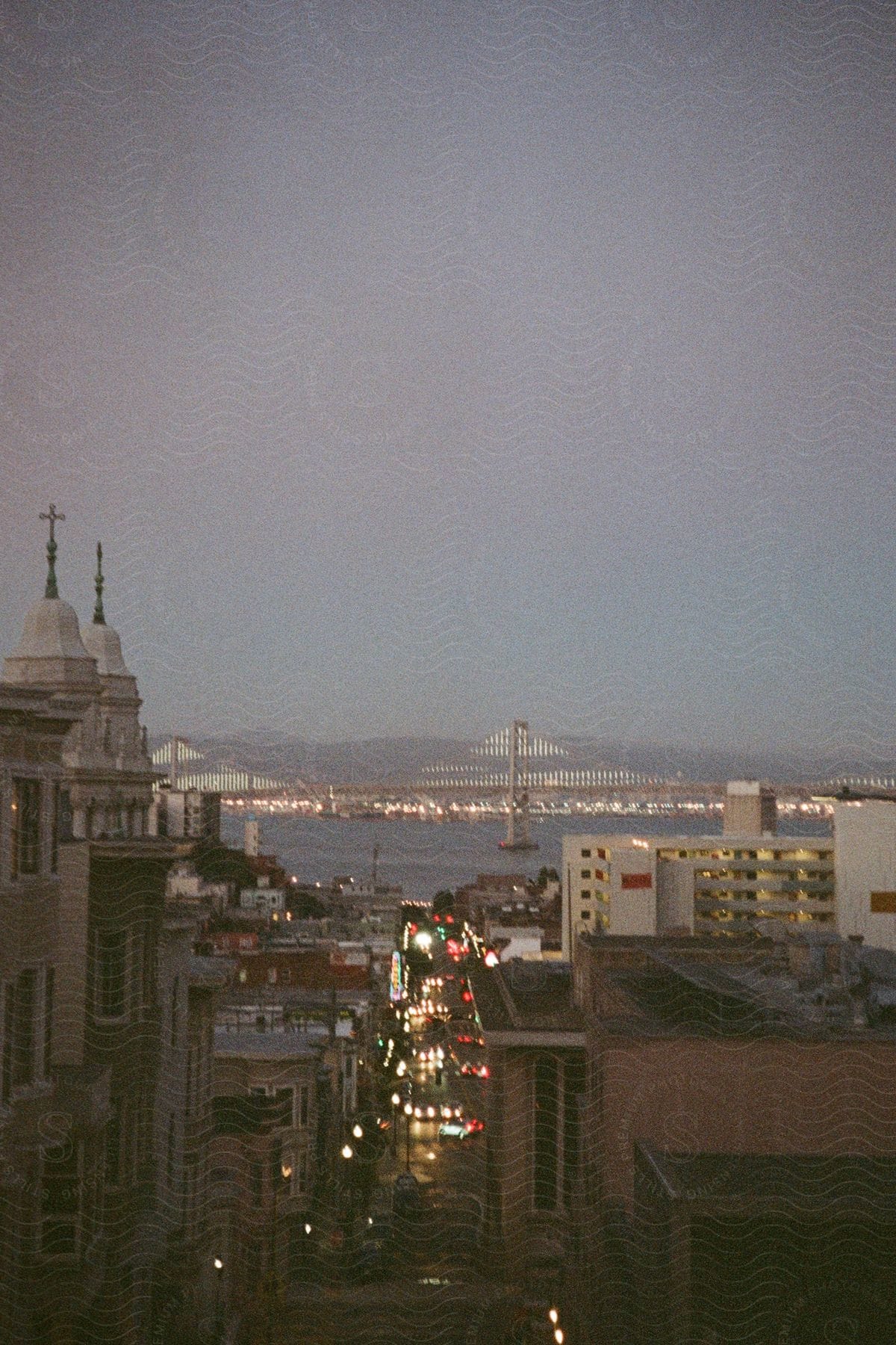 Traffic moves on a street through town along the coast and a bridge crossing the water