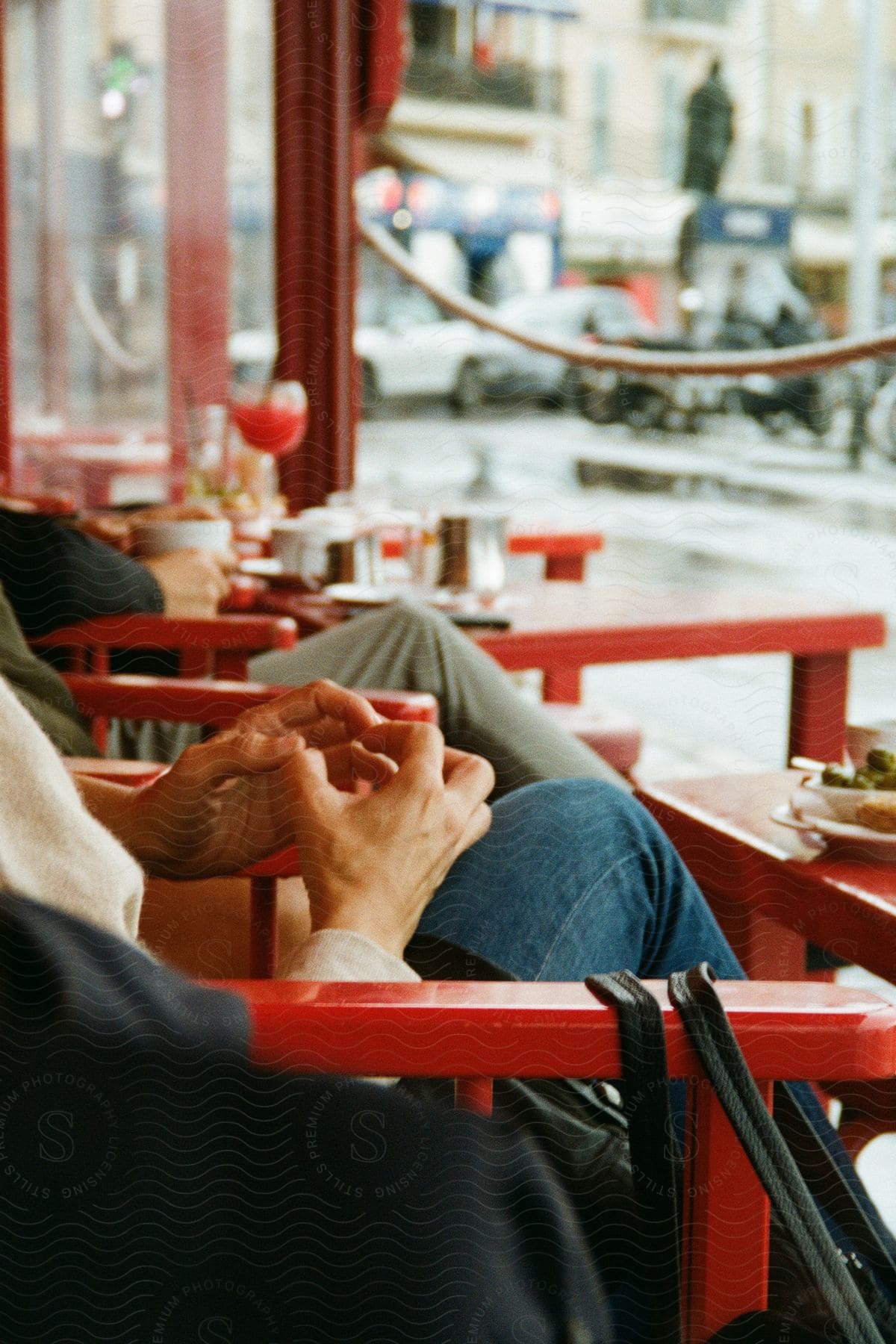 Stock photo of three people relax while sitting outside at a cafe.