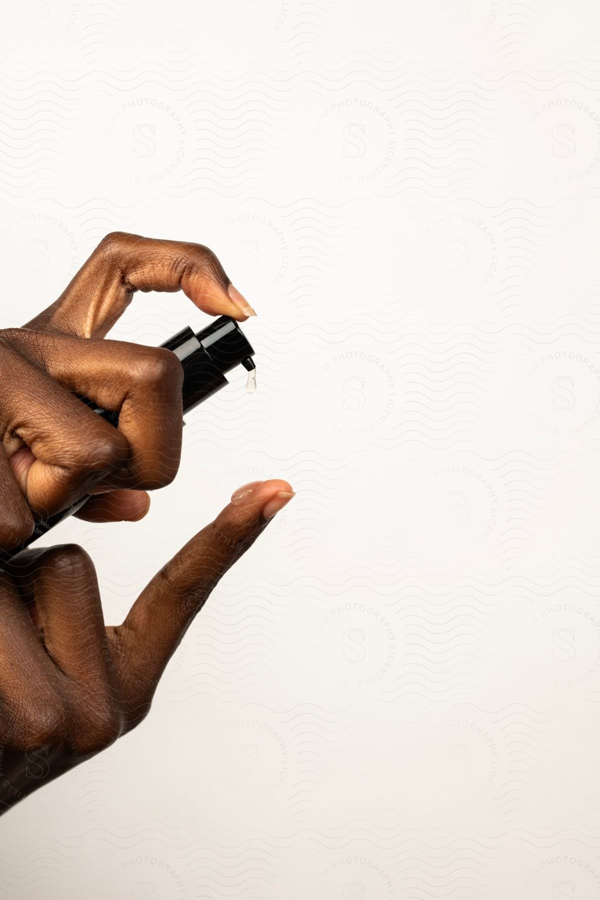 Woman's hands dropping lotion on her finger